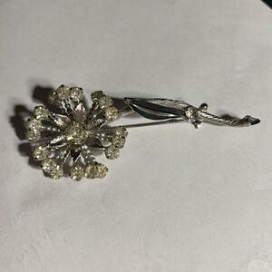 Sparkly silver flower brooch.